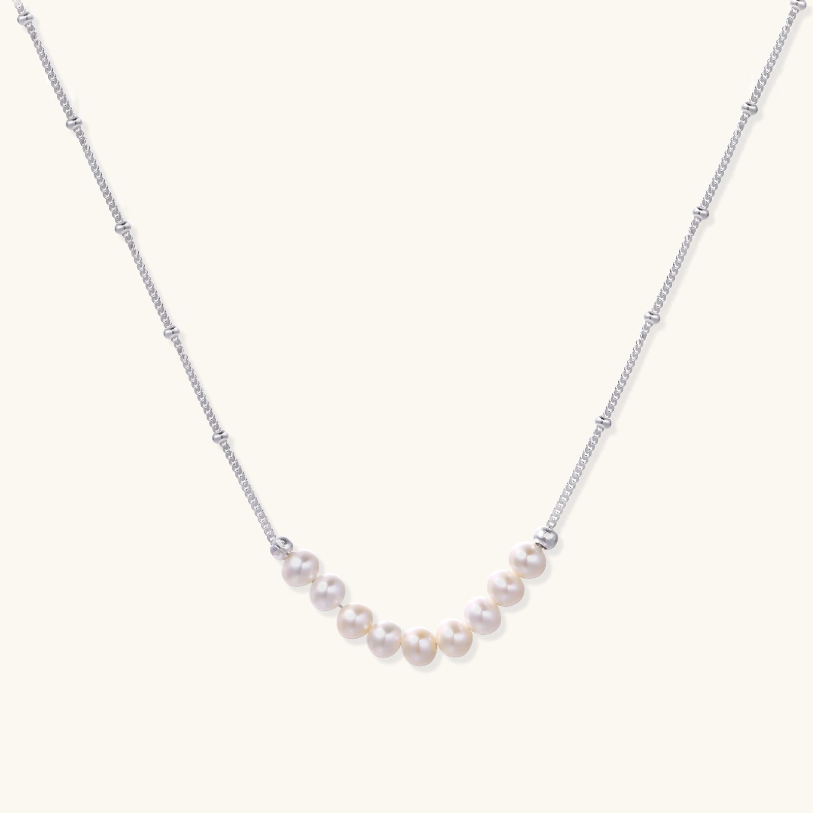 Luna pearl arc necklace in silver-tone on cream background