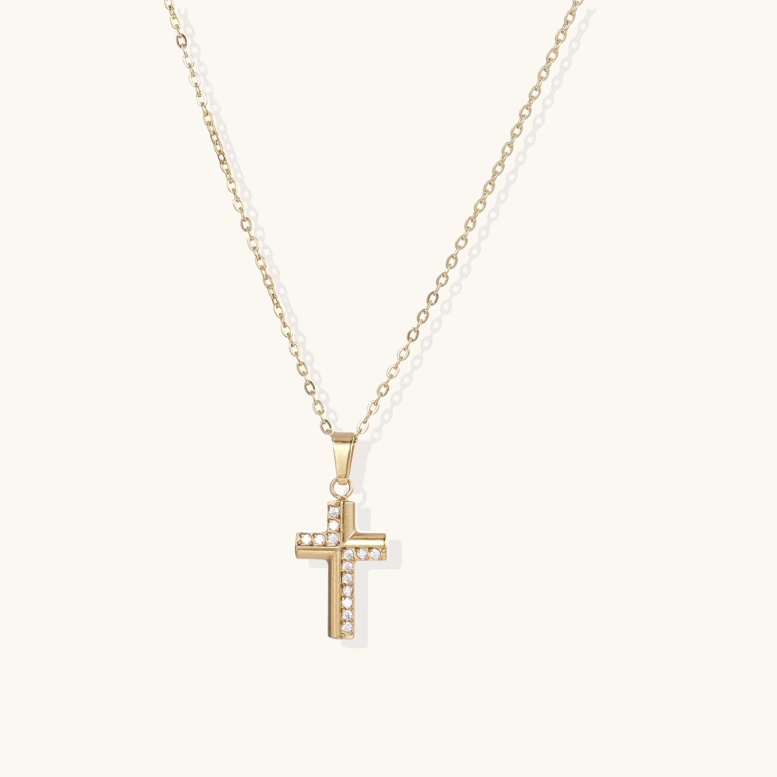 Gold-tone crystal cross necklace on white background
