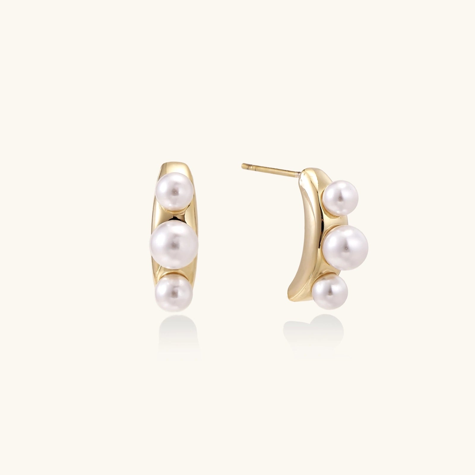 Pearl trio curve studs in gold-tone on cream background