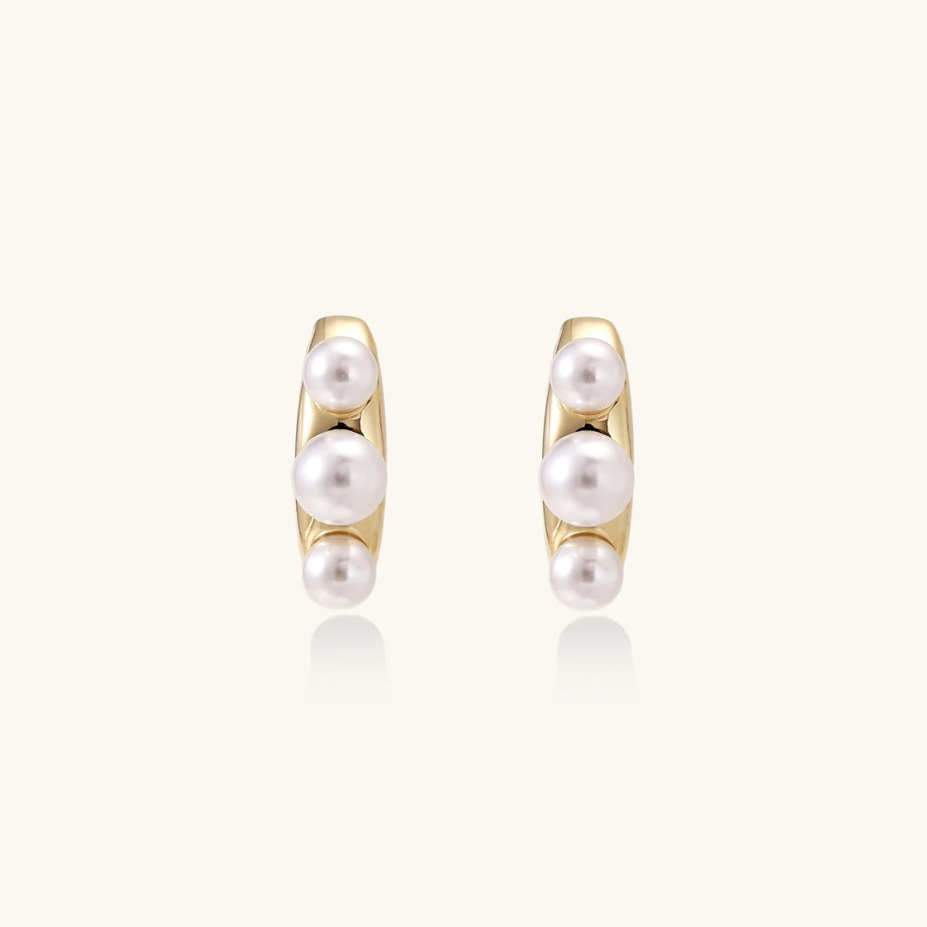 Gold-tone pearl climber studs close-up