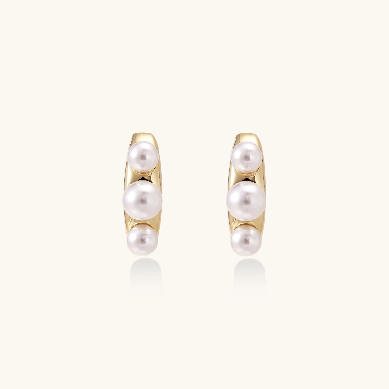Gold-tone pearl climber studs close-up