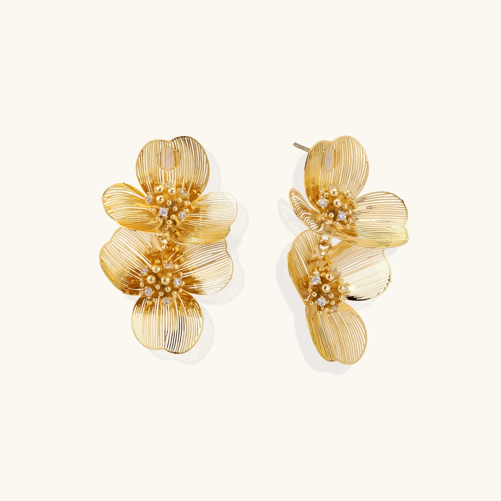 Golden bloom double flower earrings on cream background