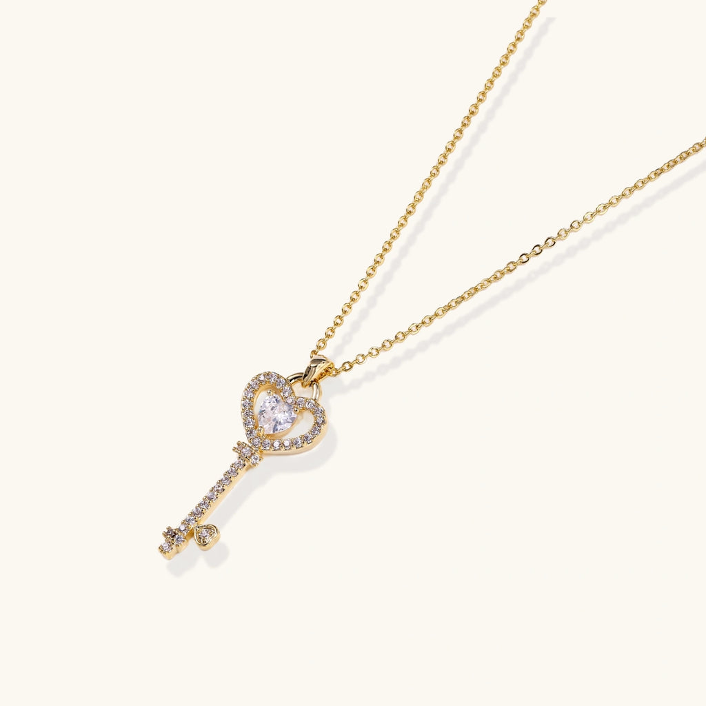 Gold-tone key pendant with crystal heart bow close-up