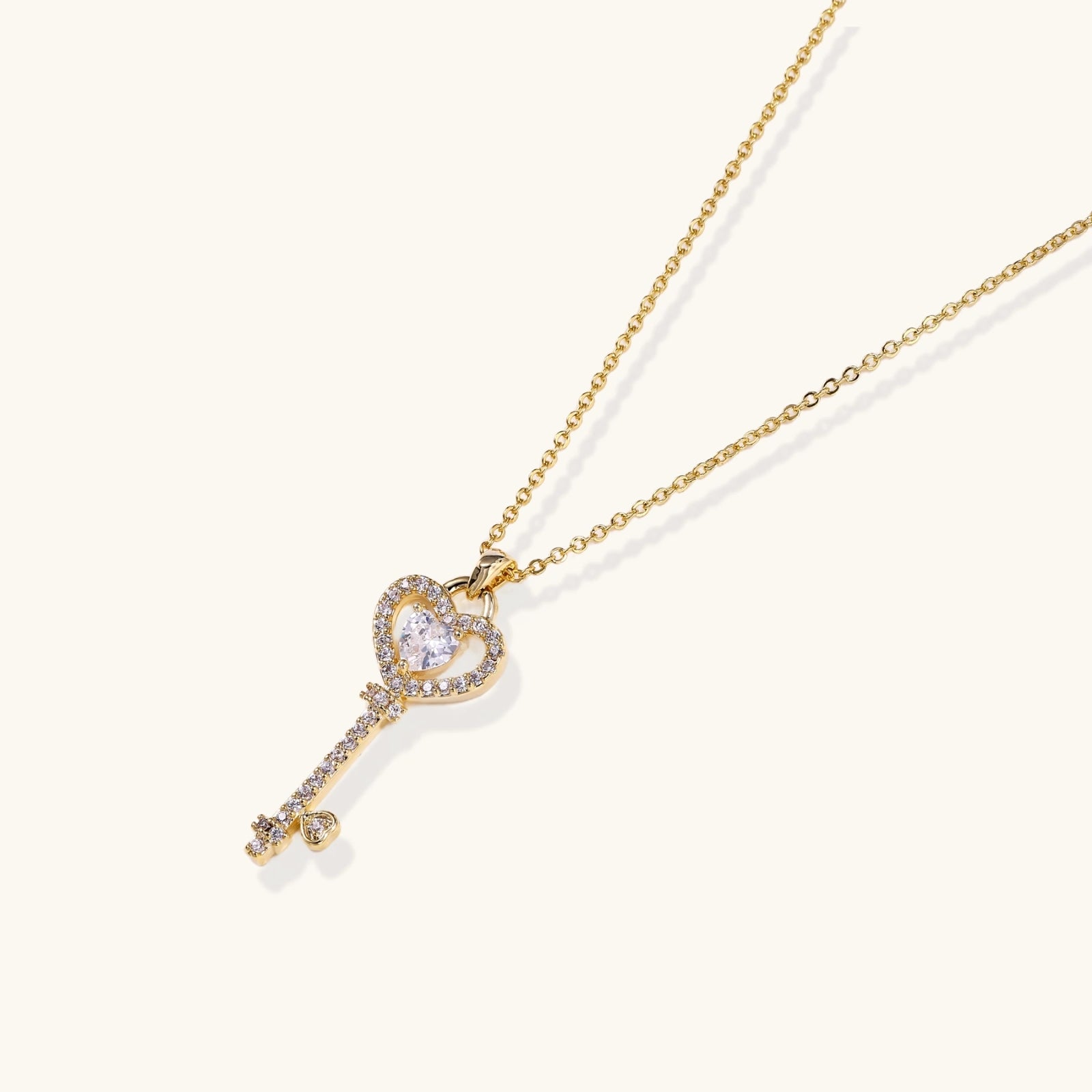 Gold-tone key pendant with crystal heart bow close-up