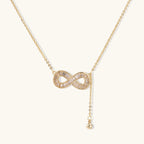 Infinity sparkle necklace in gold-tone on cream background