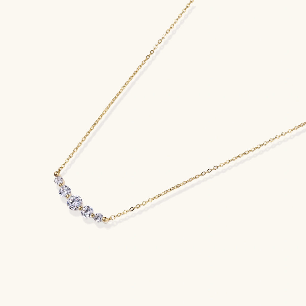 Gold-tone graduated zirconia arc pendant close-up