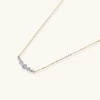 Gold-tone graduated zirconia arc pendant close-up