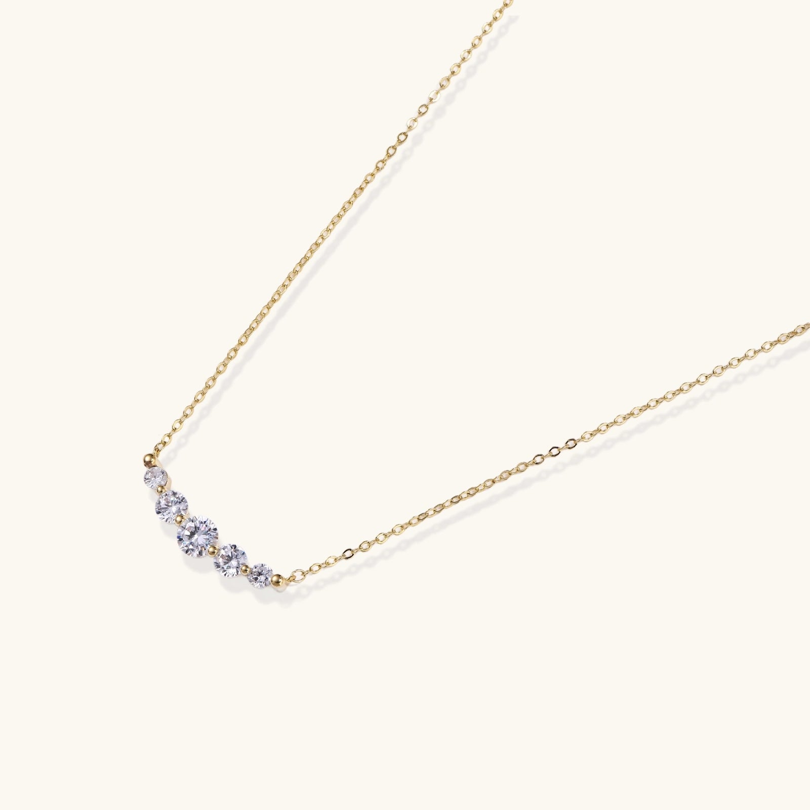 Gold-tone graduated zirconia arc pendant close-up