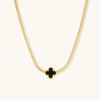 Gold-tone herringbone necklace with black enamel clover