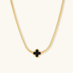 Gold-tone herringbone necklace with black enamel clover
