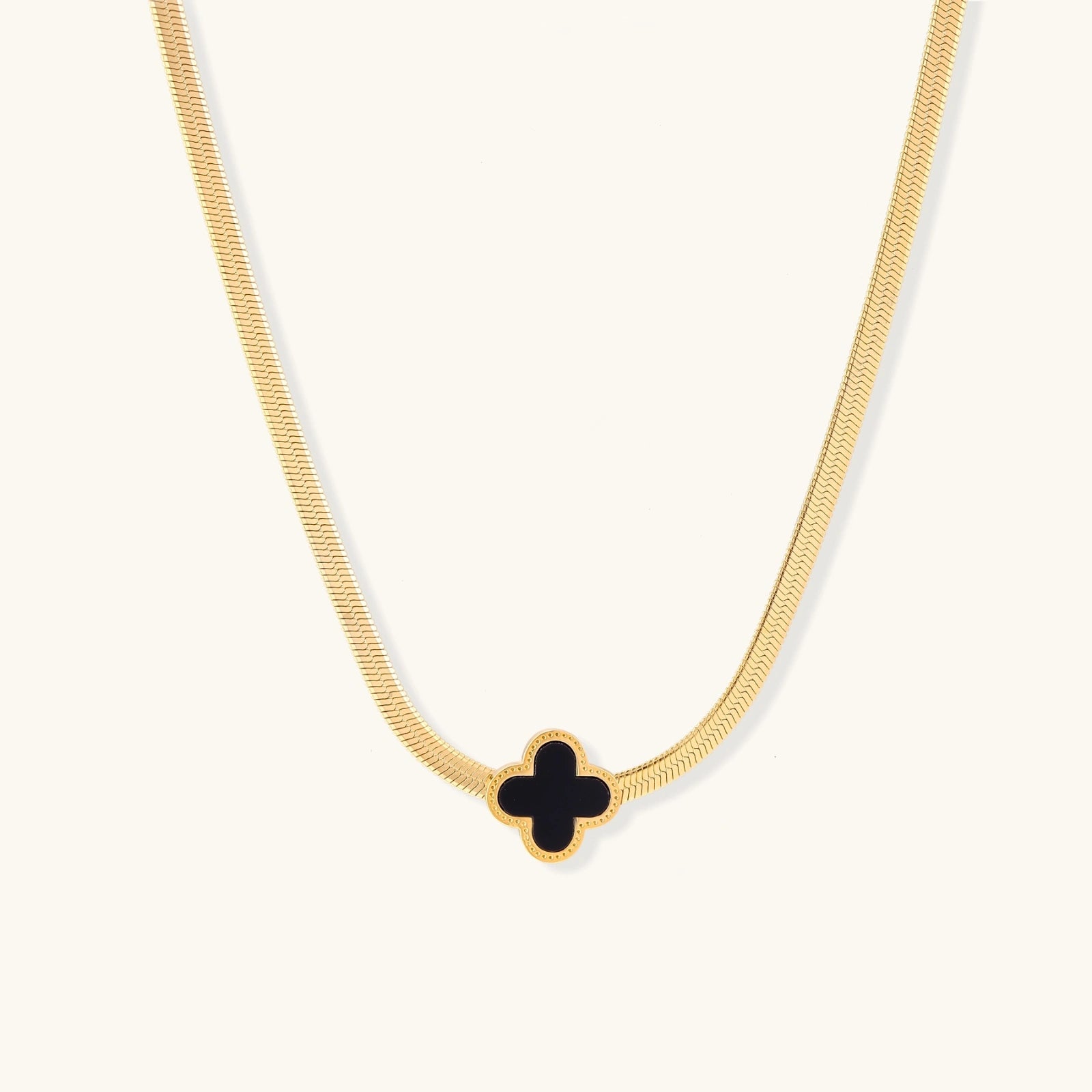 Gold-tone herringbone necklace with black enamel clover