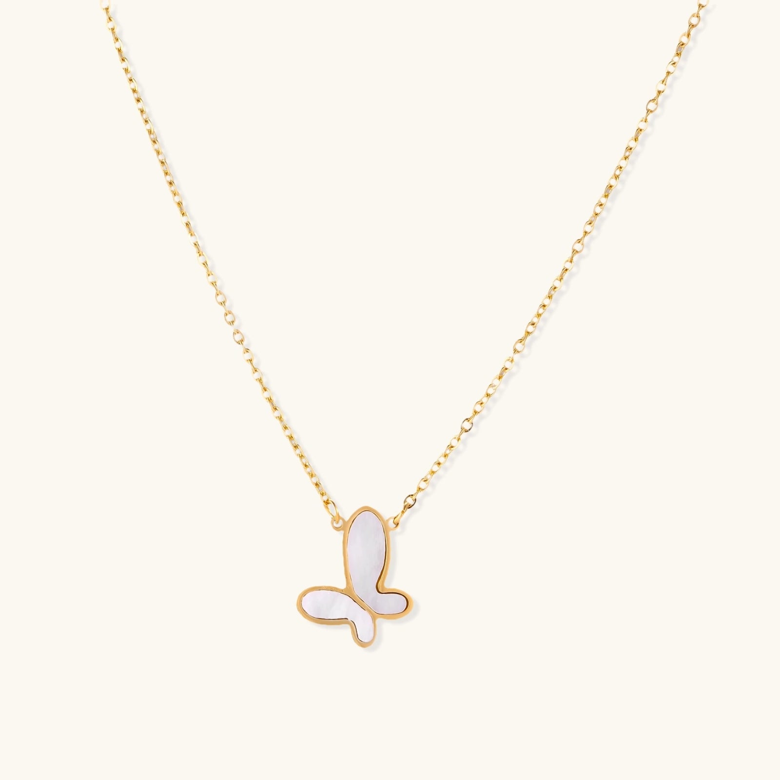Gold-tone mother-of-pearl butterfly necklace on white background