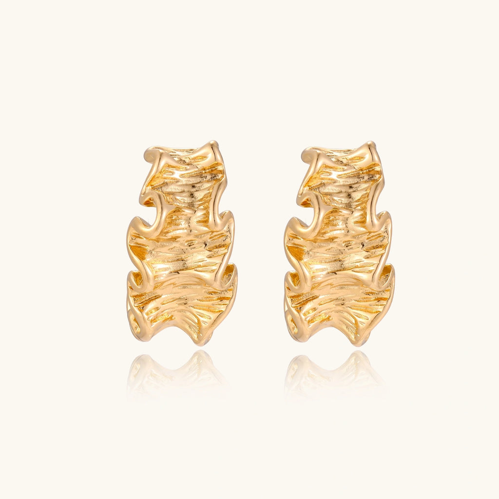 Gold-tone wave hoop earrings close-up of ripple texture