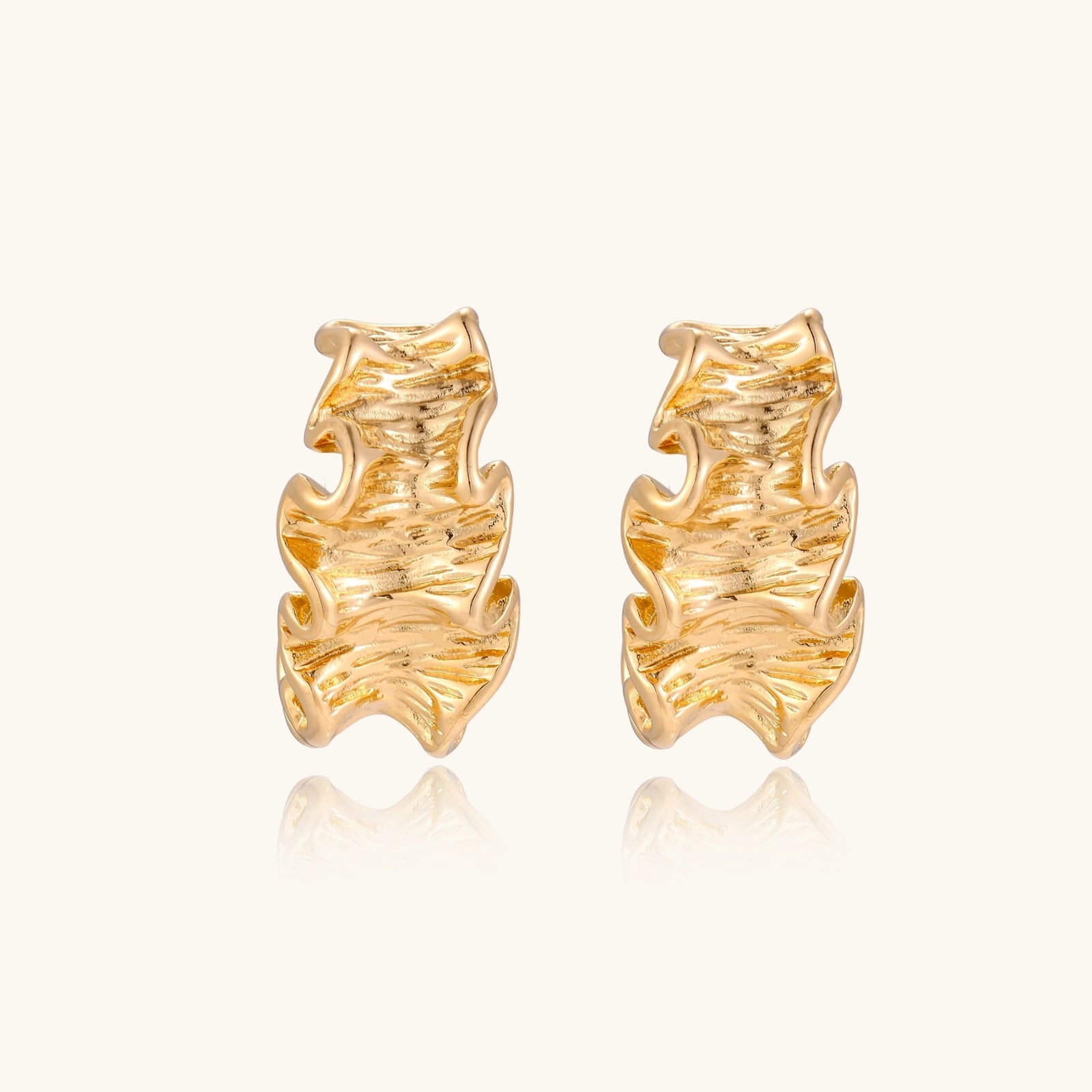 Gold-tone wave hoop earrings close-up of ripple texture