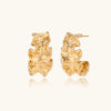 Gold-tone wave-textured hoop earrings on white background