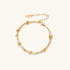 Gold-tone triple-strand beaded bracelet on cream background