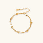 Gold-tone triple-strand beaded bracelet on cream background