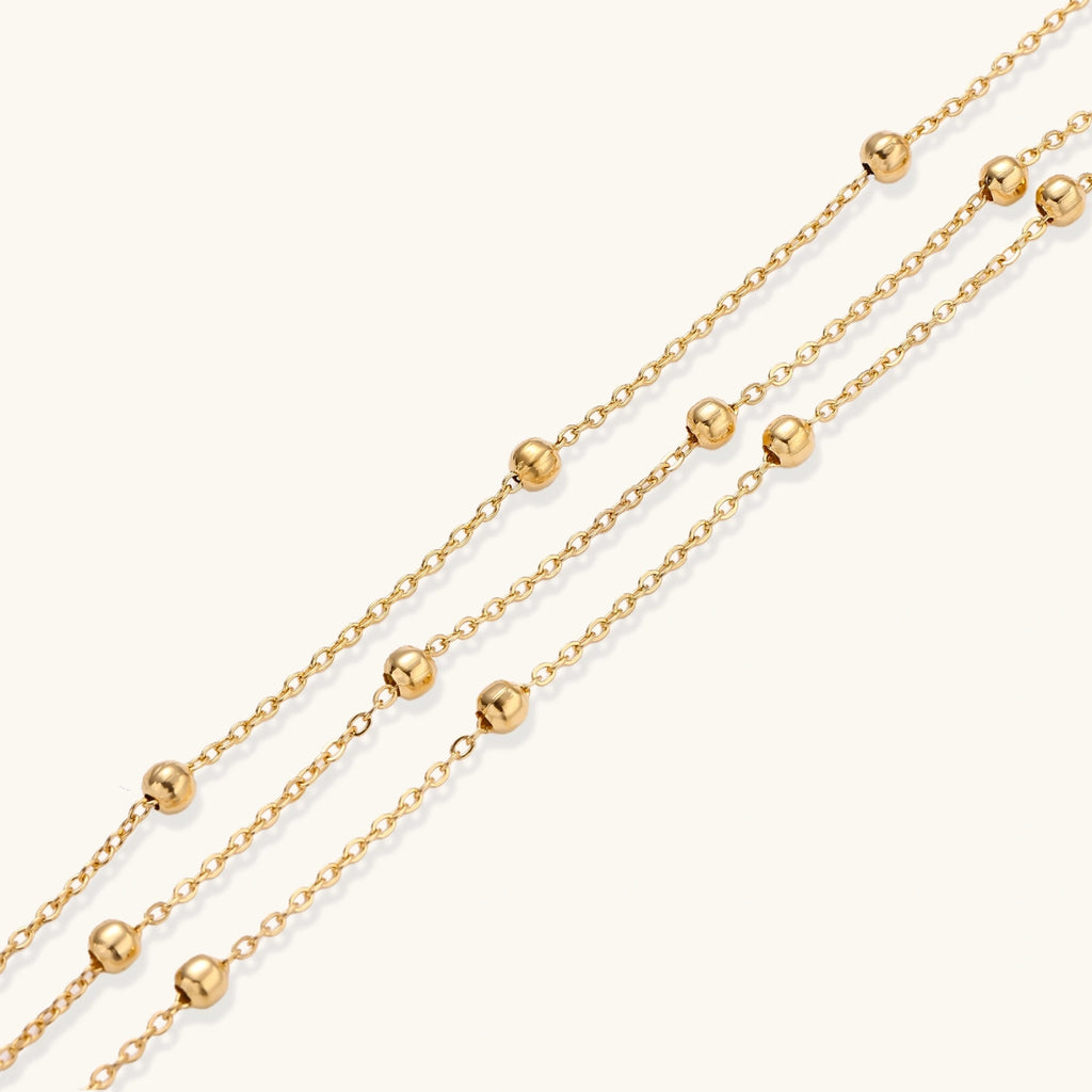 Three-strand gold-tone sphere-bead bracelet close-up