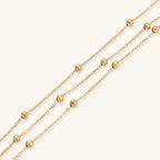 Three-strand gold-tone sphere-bead bracelet close-up