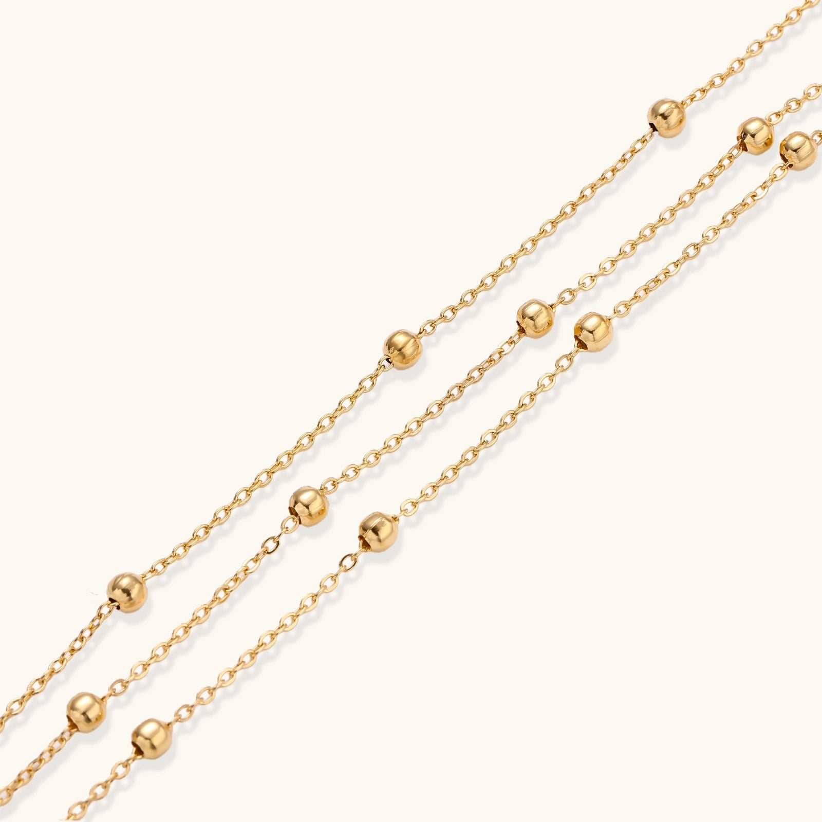 Three-strand gold-tone sphere-bead bracelet close-up