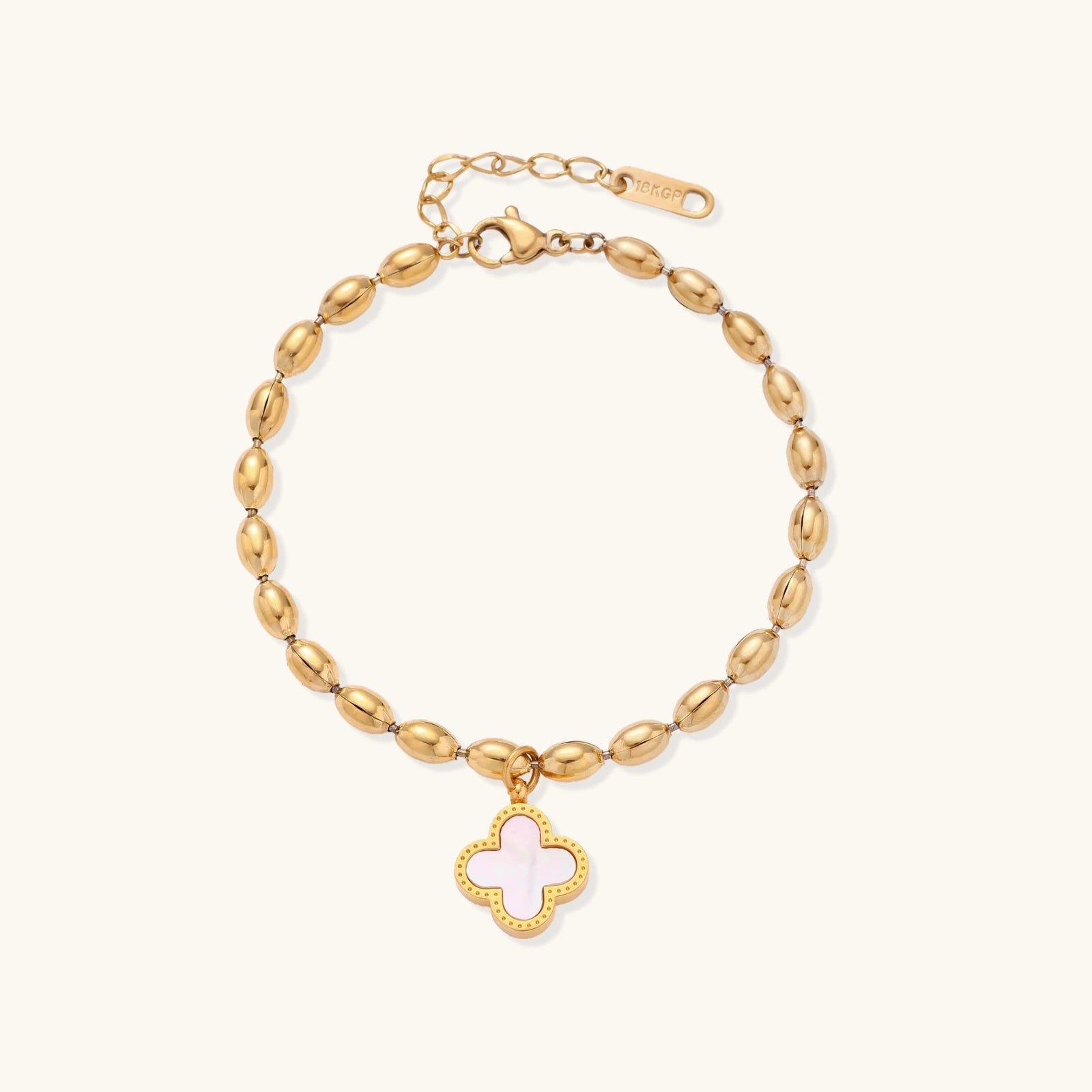 Gold-tone beaded clover bracelet with mother-of-pearl inlay on cream background