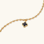 Gold-tone quatrefoil clover charm detail