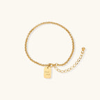 Gold-tone Good Luck engraved chain bracelet on cream background