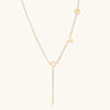 Gold-tone LOVE lariat Y-drop necklace on cream background