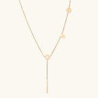 Gold-tone LOVE lariat Y-drop necklace on cream background
