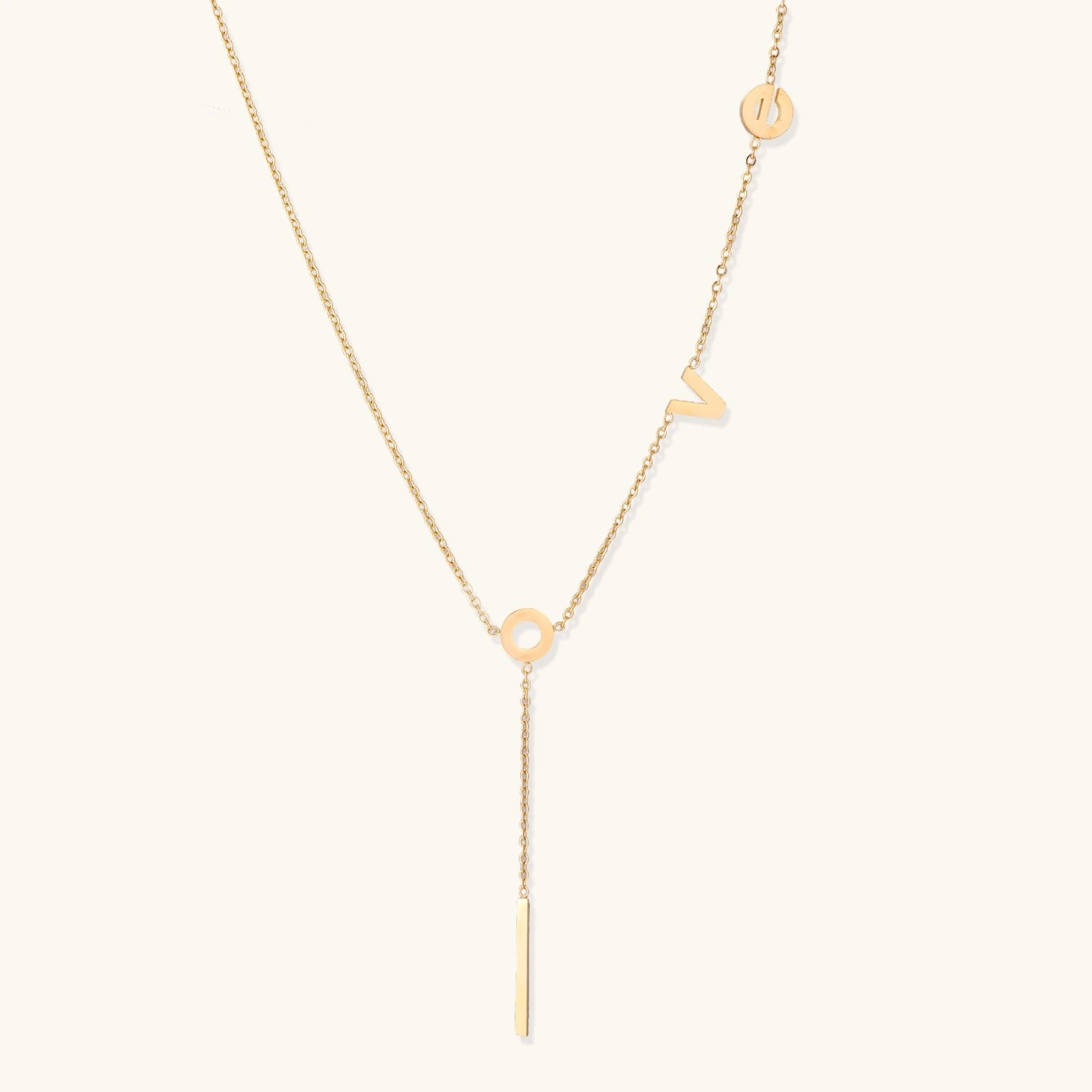 Gold-tone LOVE lariat Y-drop necklace on cream background