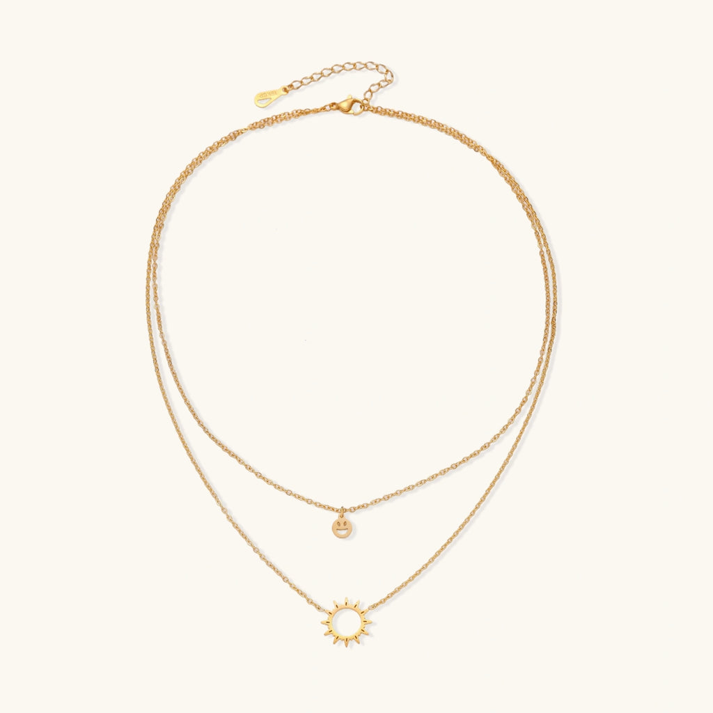 Layered gold-tone charm necklace detail