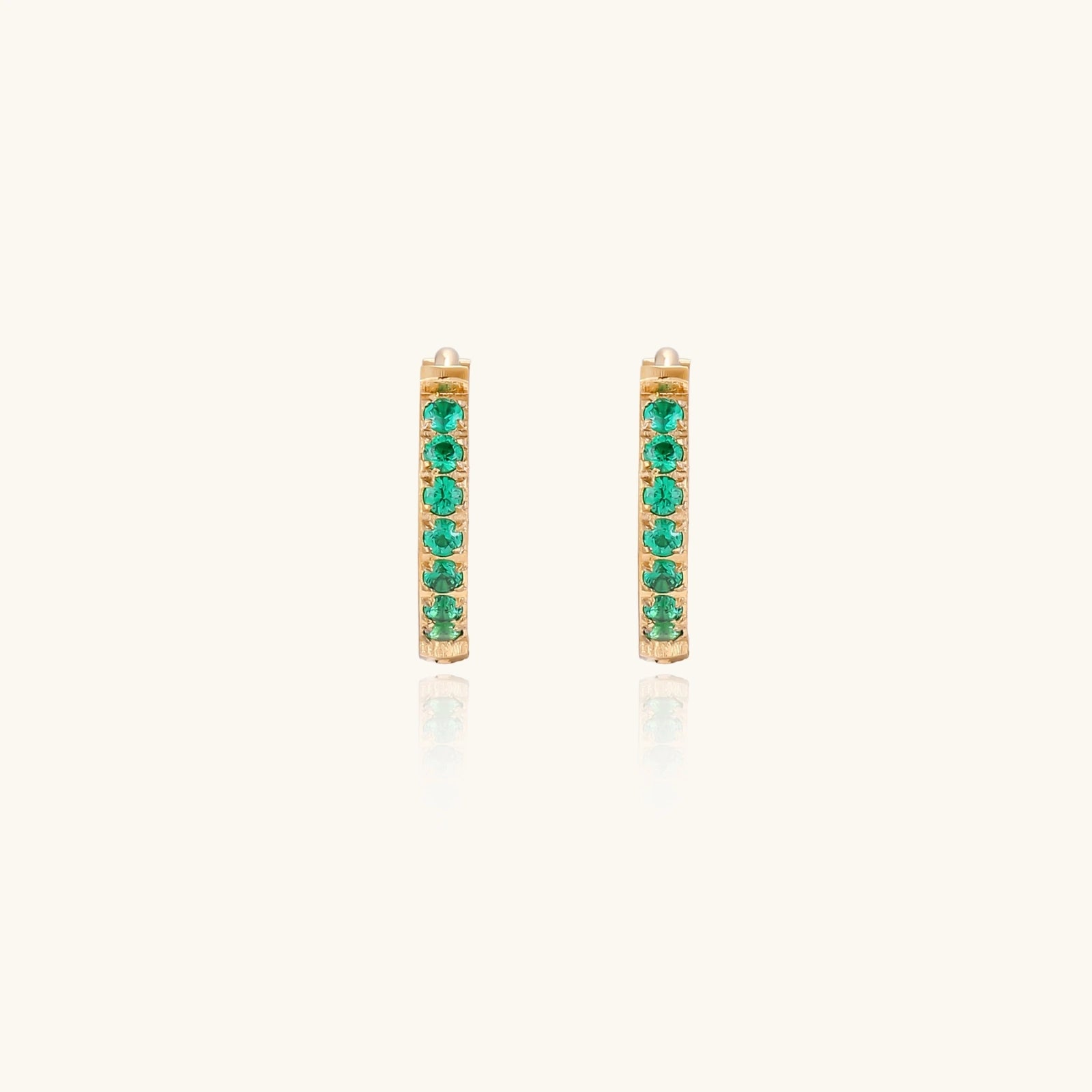 Green cubic zirconia gold-tone huggies close-up