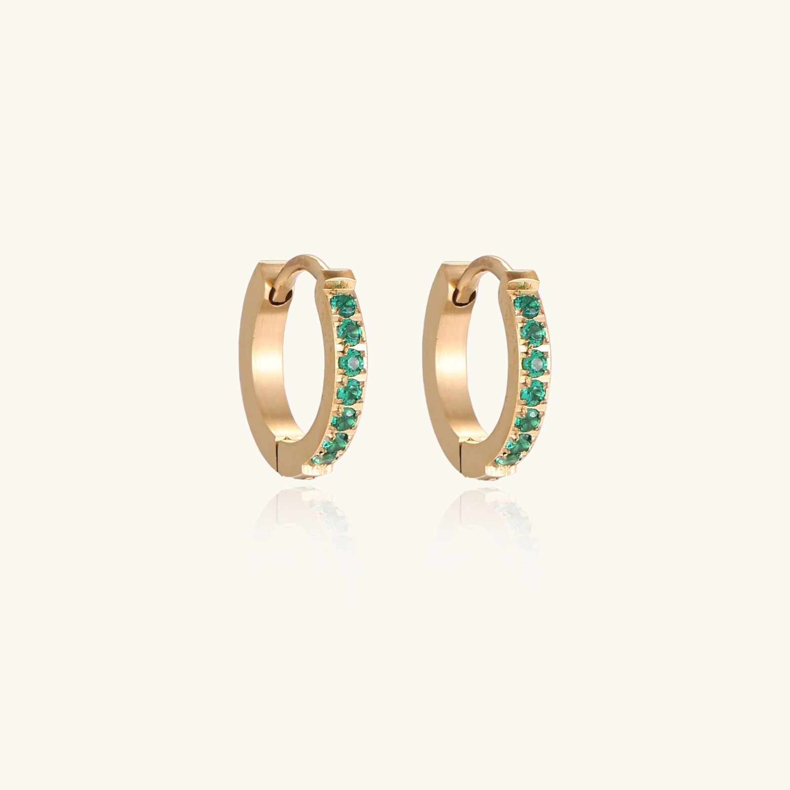 Gold-tone emerald huggies shown as a pair