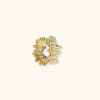 Gold-tone statement ring on beige background