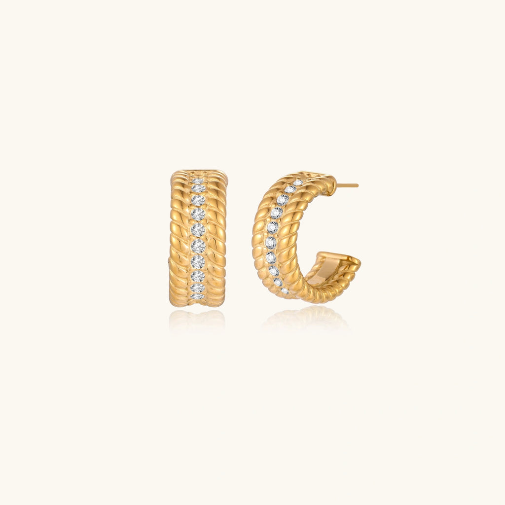Chunky textured gold-tone hoop earrings on cream background