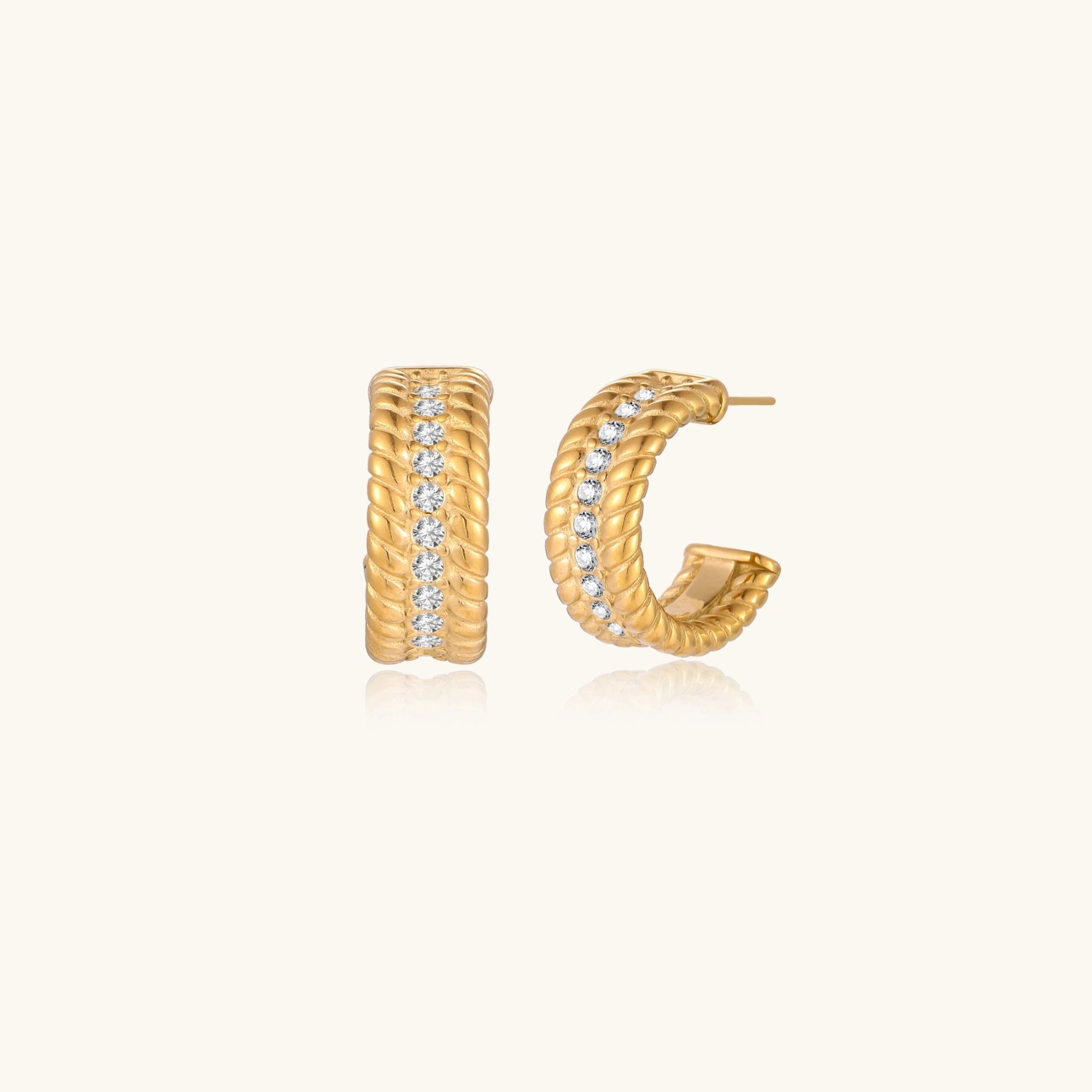 Chunky textured gold-tone hoop earrings on cream background