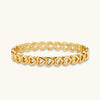 Gold-tone linked hearts bangle bracelet on white background