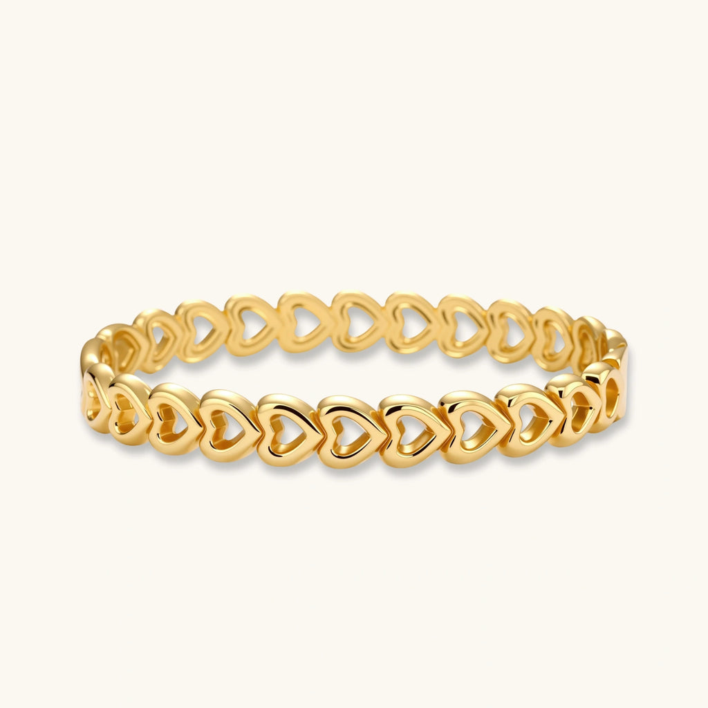 Gold-tone linked hearts bangle bracelet on white background