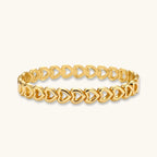 Gold-tone linked hearts bangle bracelet on white background