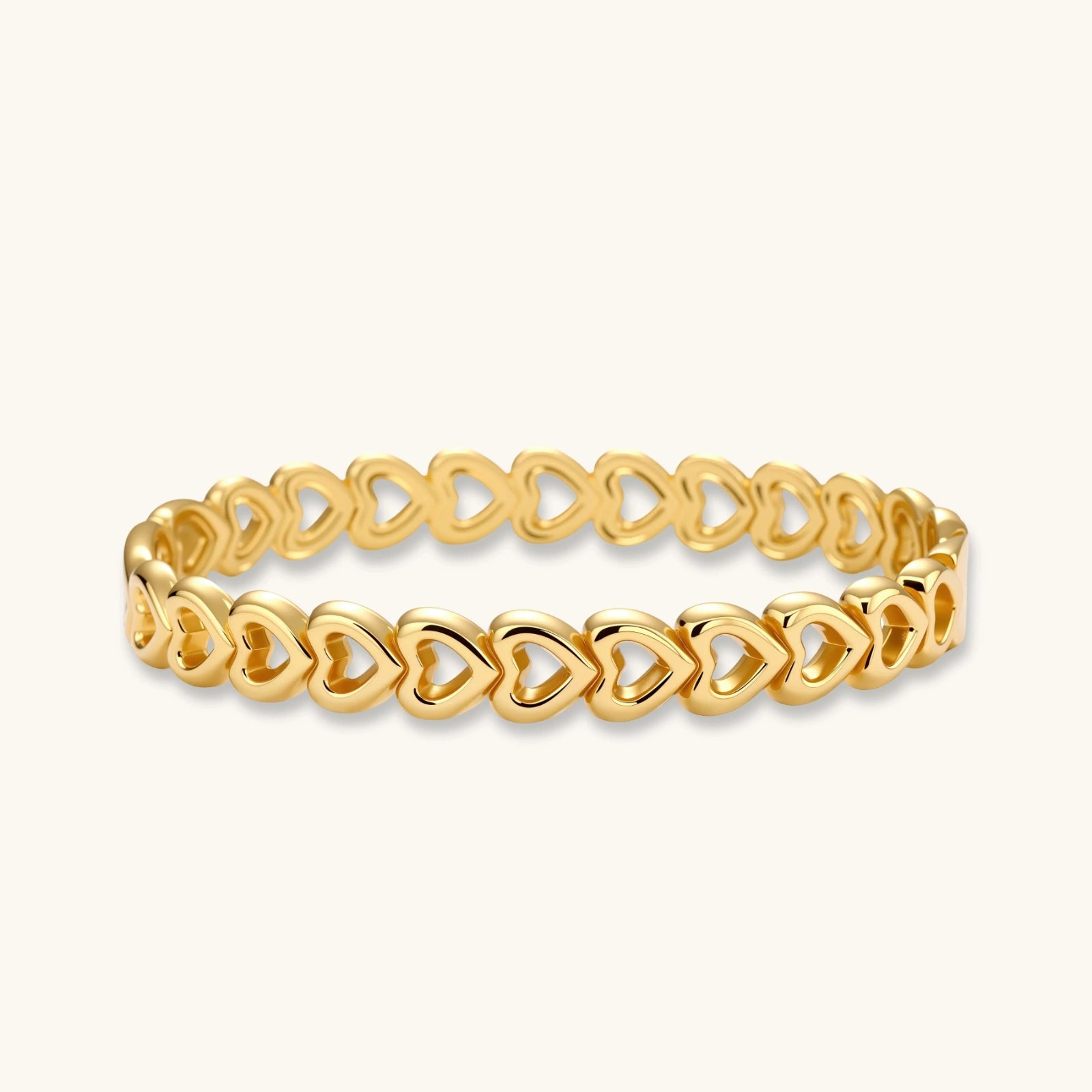 Gold-tone linked hearts bangle bracelet on white background