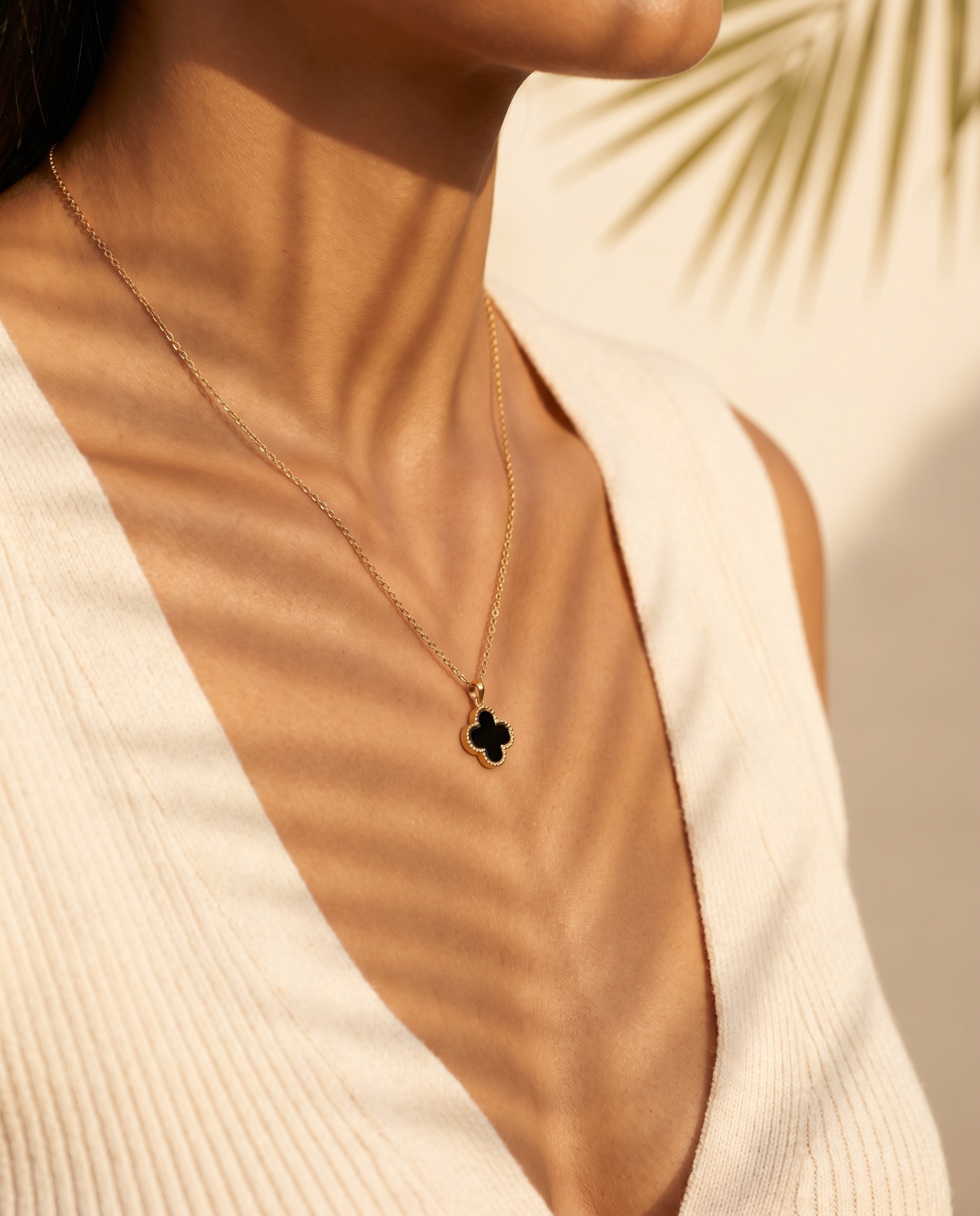 Clover necklace shown on model in warm sunlight