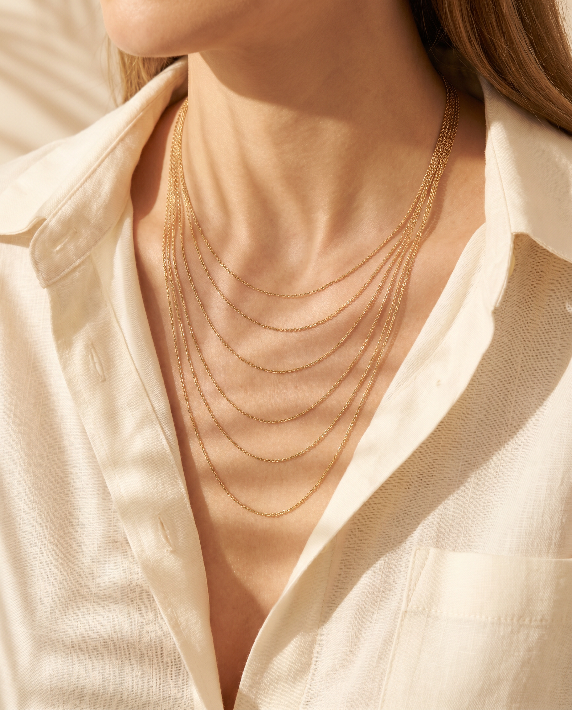 Layered snake-chain necklace shown on model in sunlight